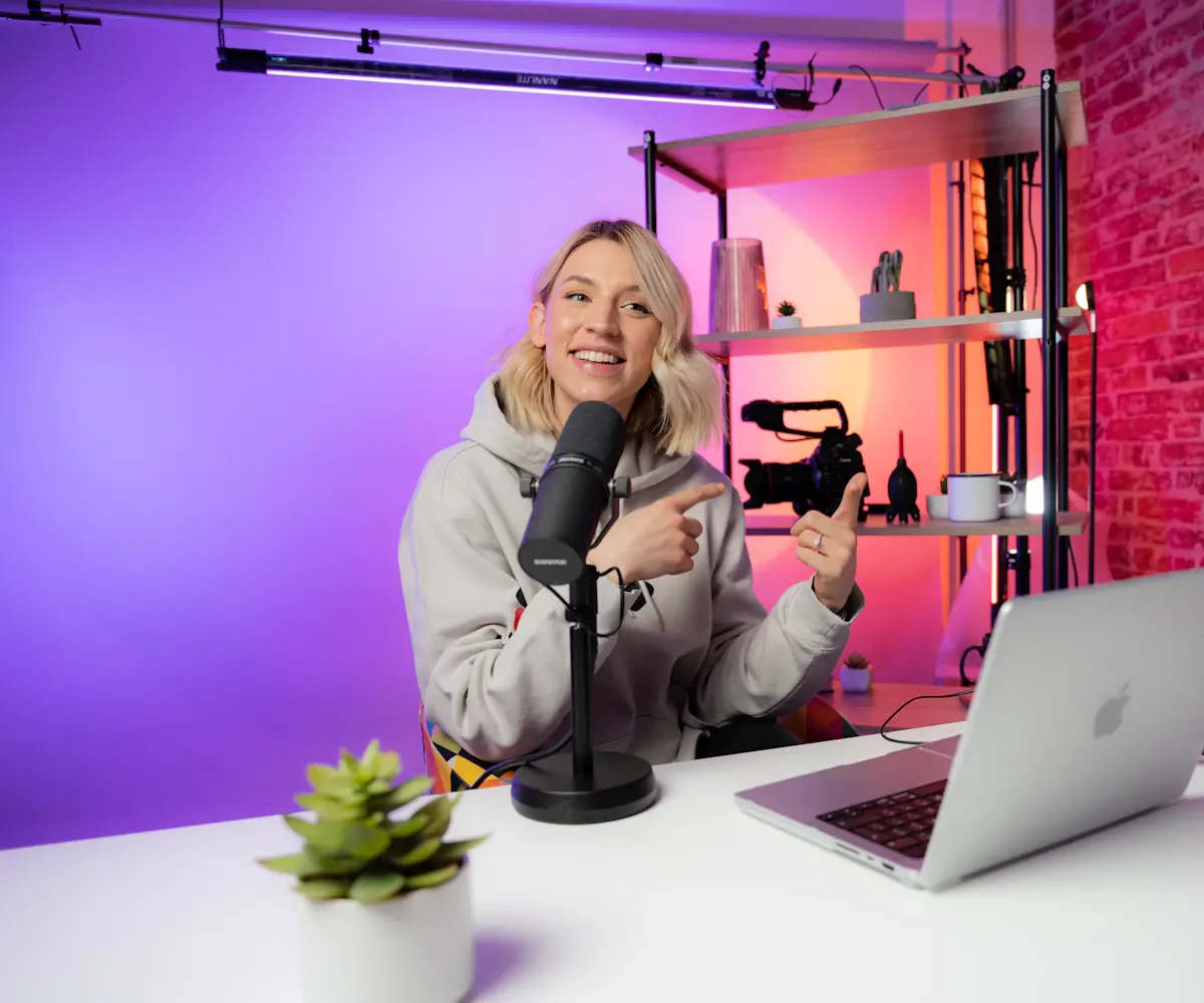 A content creator recording at a desk with a camera and laptop